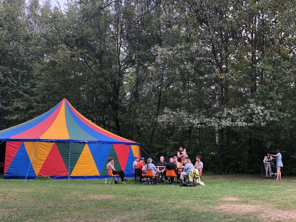 Zirkuszelt und Menschen, am Waldrand